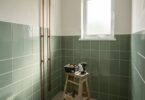 Salle de bain moderne en cours de rénovation avec carrelage vert sauge et outils